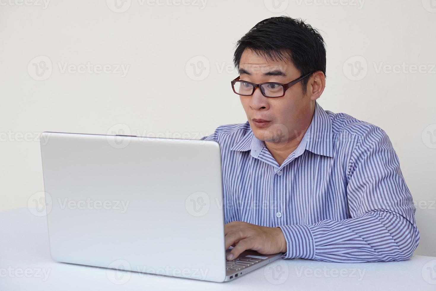 Asian man feels surprised and excited during surfing internet on laptop computer. Concept , Emotional expression. Omg.Wow. feeling. Online working, working with data. photo