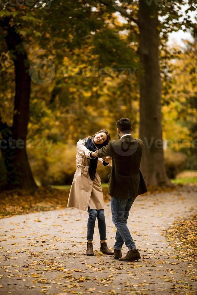 pareja joven divirtiéndose en el parque de otoño foto