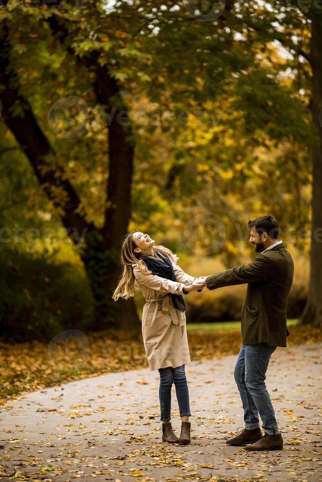 pareja joven divirtiéndose en el parque de otoño foto