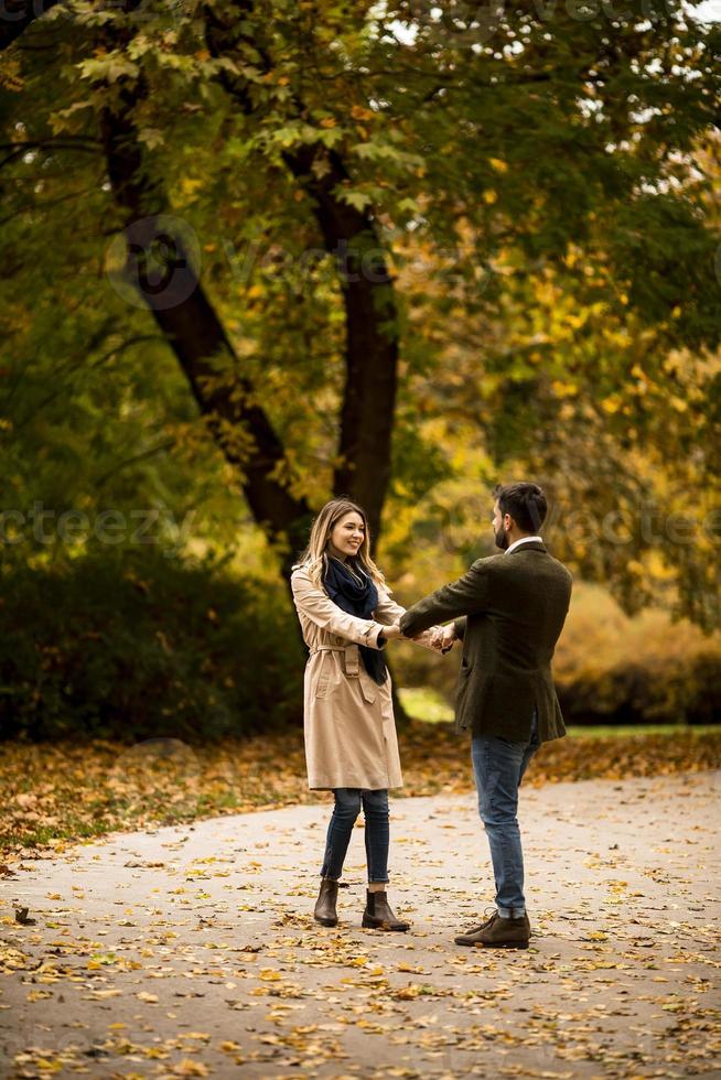 pareja joven divirtiéndose en el parque de otoño foto