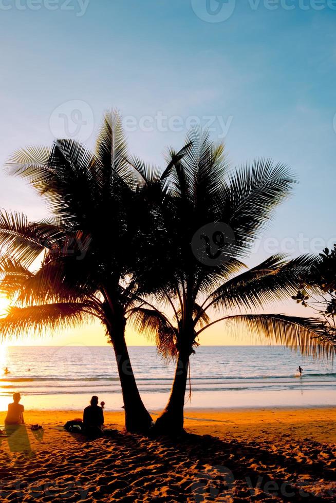 Silhouette of beautiful sunset on the sea beach with palm tree for travel in holiday relax time, photo