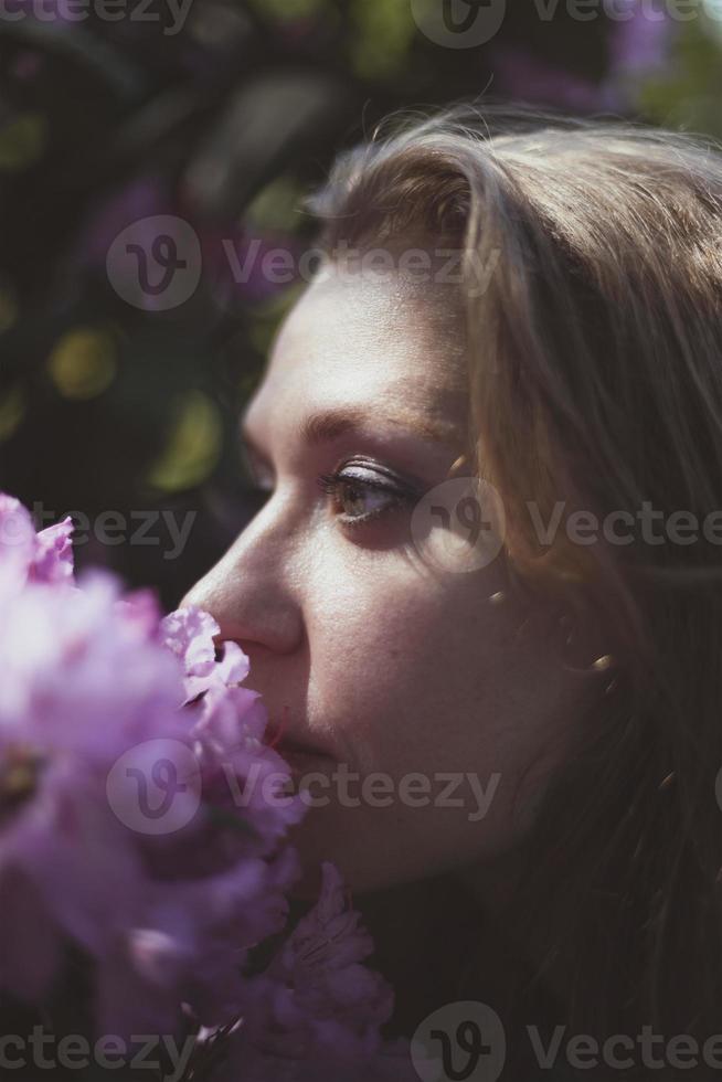 cerrar mujer oliendo arbusto floreciente con flores rosadas imagen de retrato foto