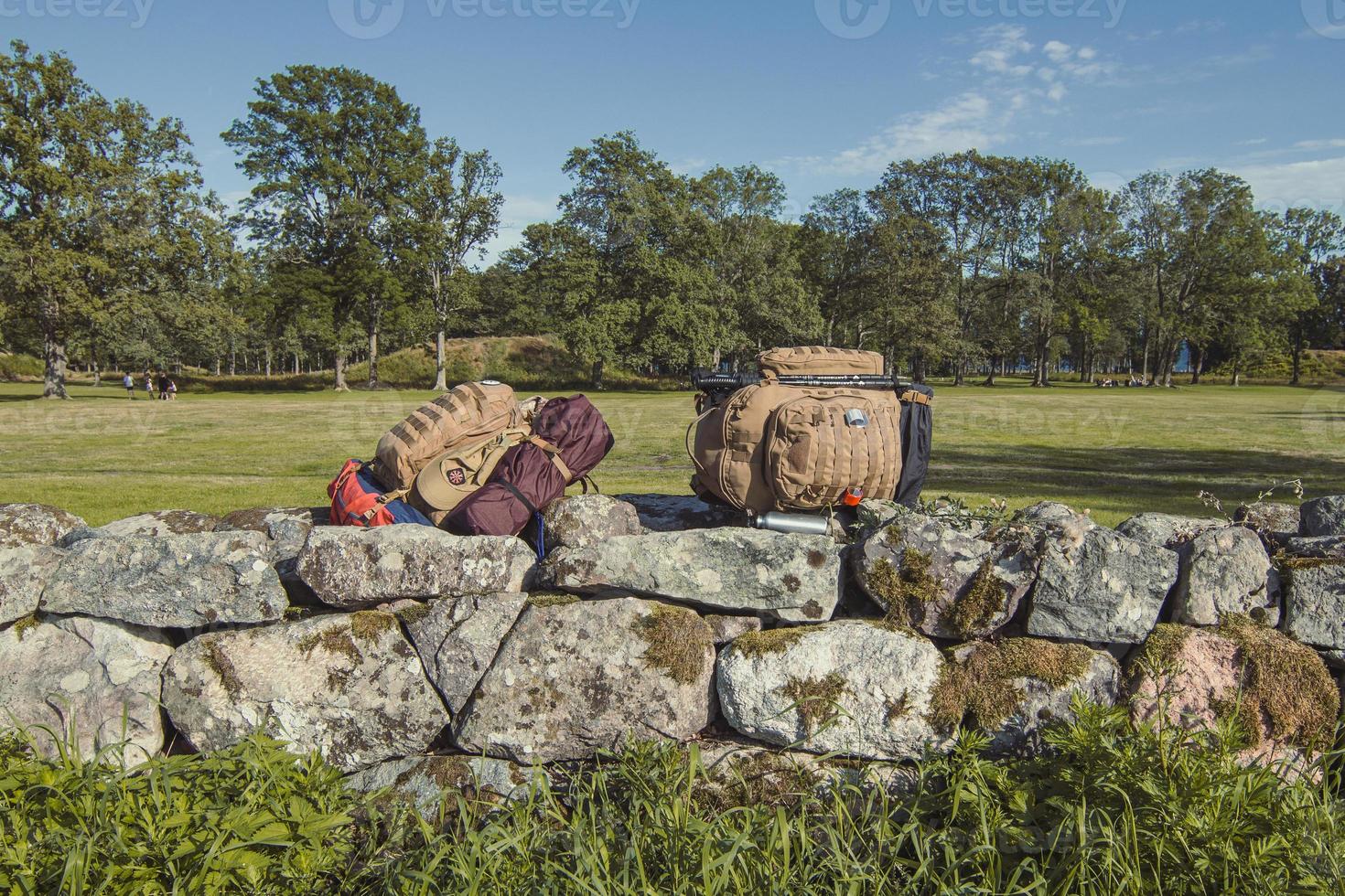 Hiker backpacks on limestone fence landscape photo