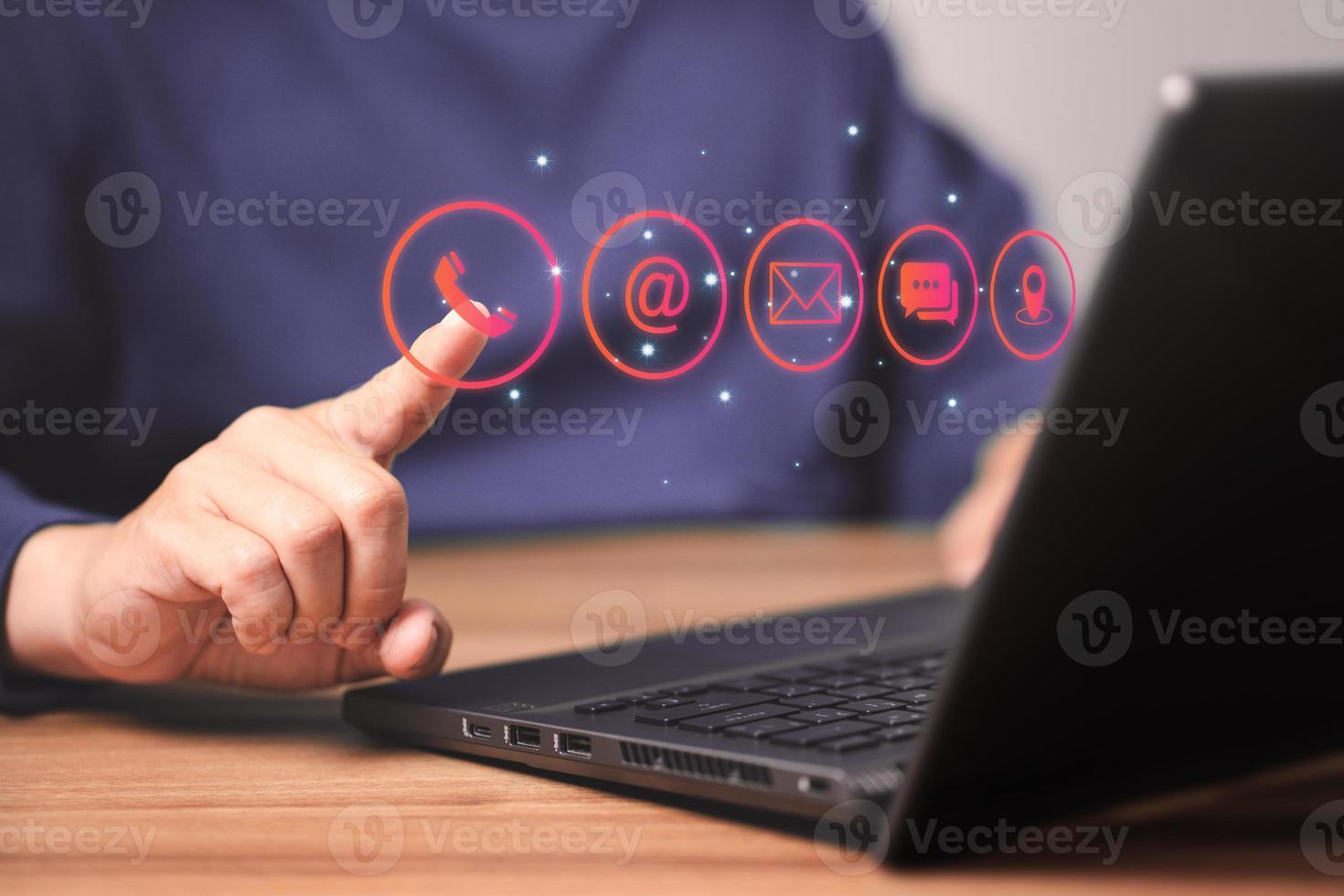 Man using a computer laptop and touching on technology virtual screen contact icons. Contact us or Customer support hotline people connect. photo