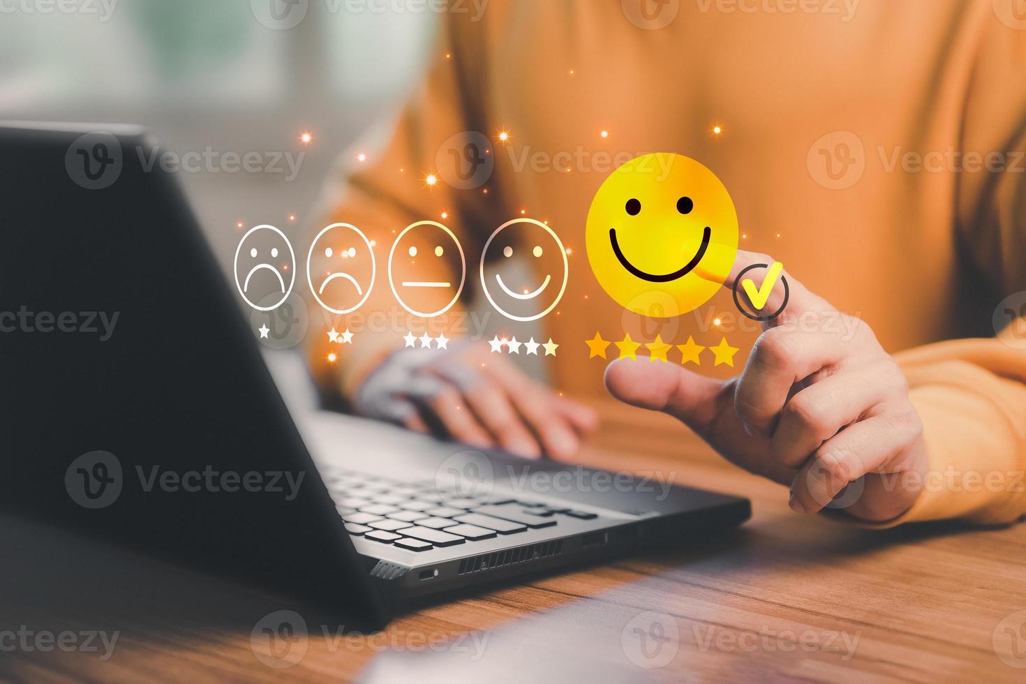 Man hand using computer laptop with popup five star icon for feedback review satisfaction service, testimonial. Customer service experience and business satisfaction survey. photo
