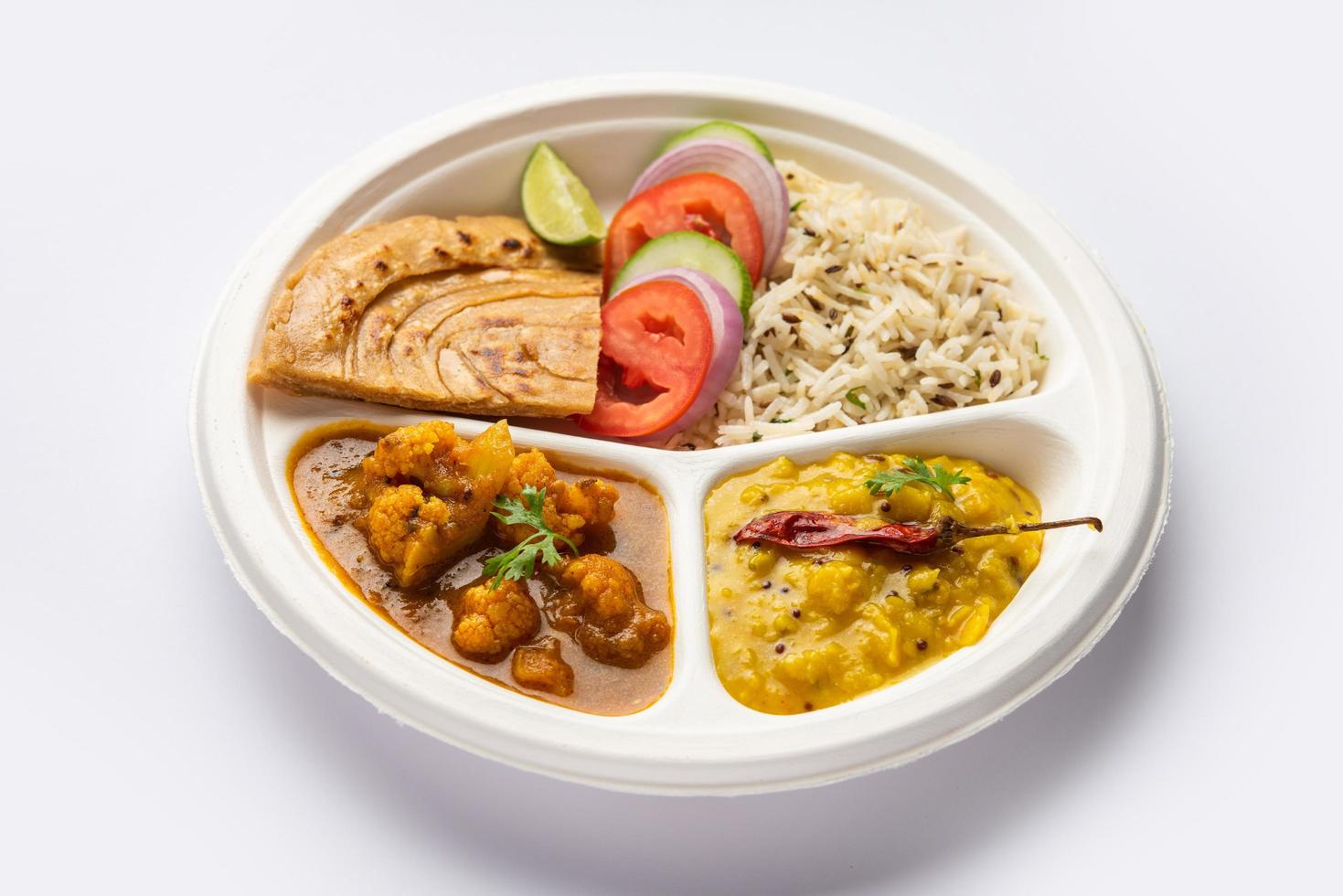 Indian mini meal parcel platter or combo thali with Gobi Masala, roti, dal tarka, jeera rice, salad photo
