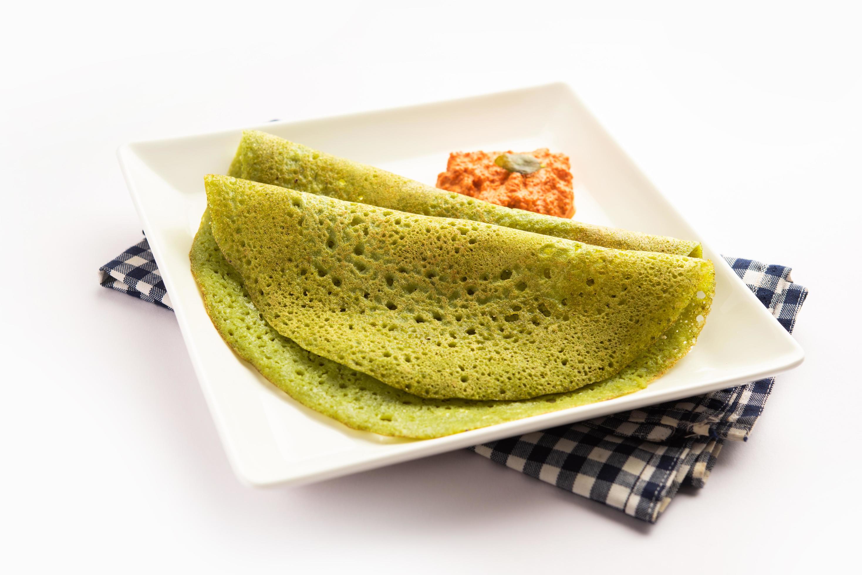 Palak dosa made using mixing spinach or keerai in batter, served with ...