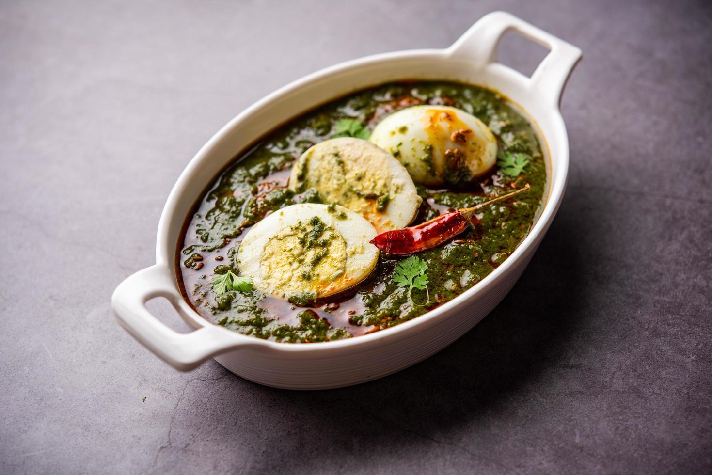 Spinach egg curry is an Indian non vegetarian dish made using palak gravy with eggs photo