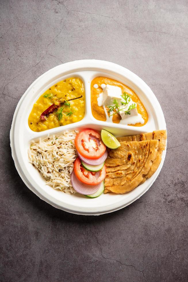 North Indian mini meal, parcel platter or combo thali with paneer butter masala, roti, dal and rice photo