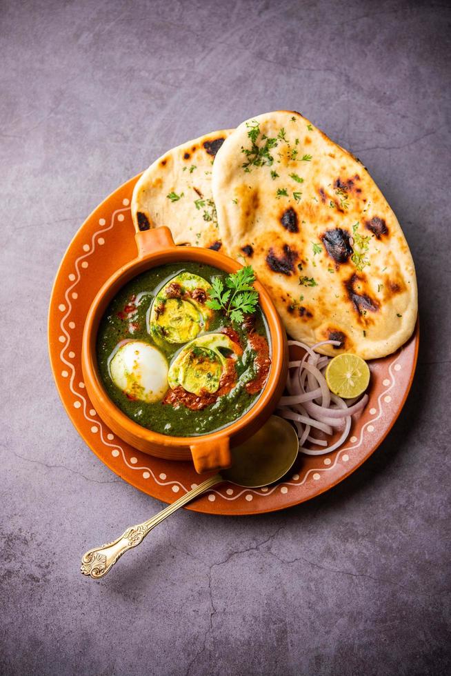 el curry de huevo y espinacas es un plato indio no vegetariano hecho con salsa palak con huevos foto