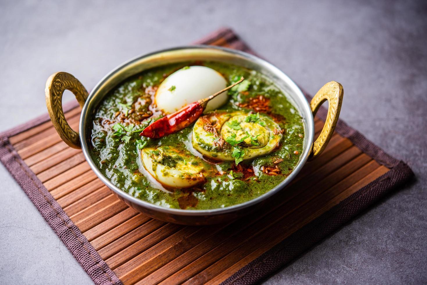 Spinach egg curry is an Indian non vegetarian dish made using palak gravy with eggs photo