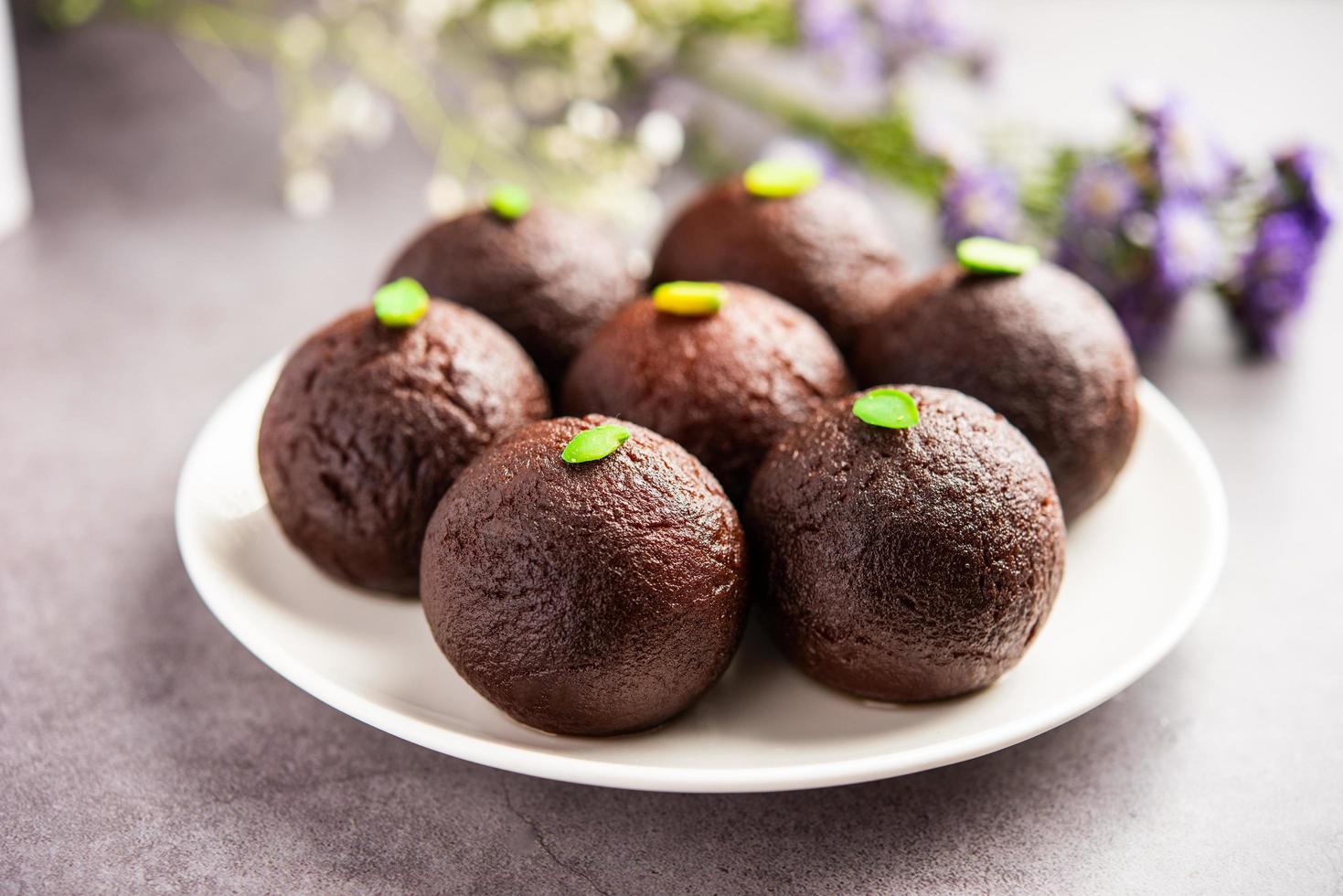 comida dulce india dulce gulab jamun negro también conocido como kala jamun, jamun negro o mermelada seca de kala foto