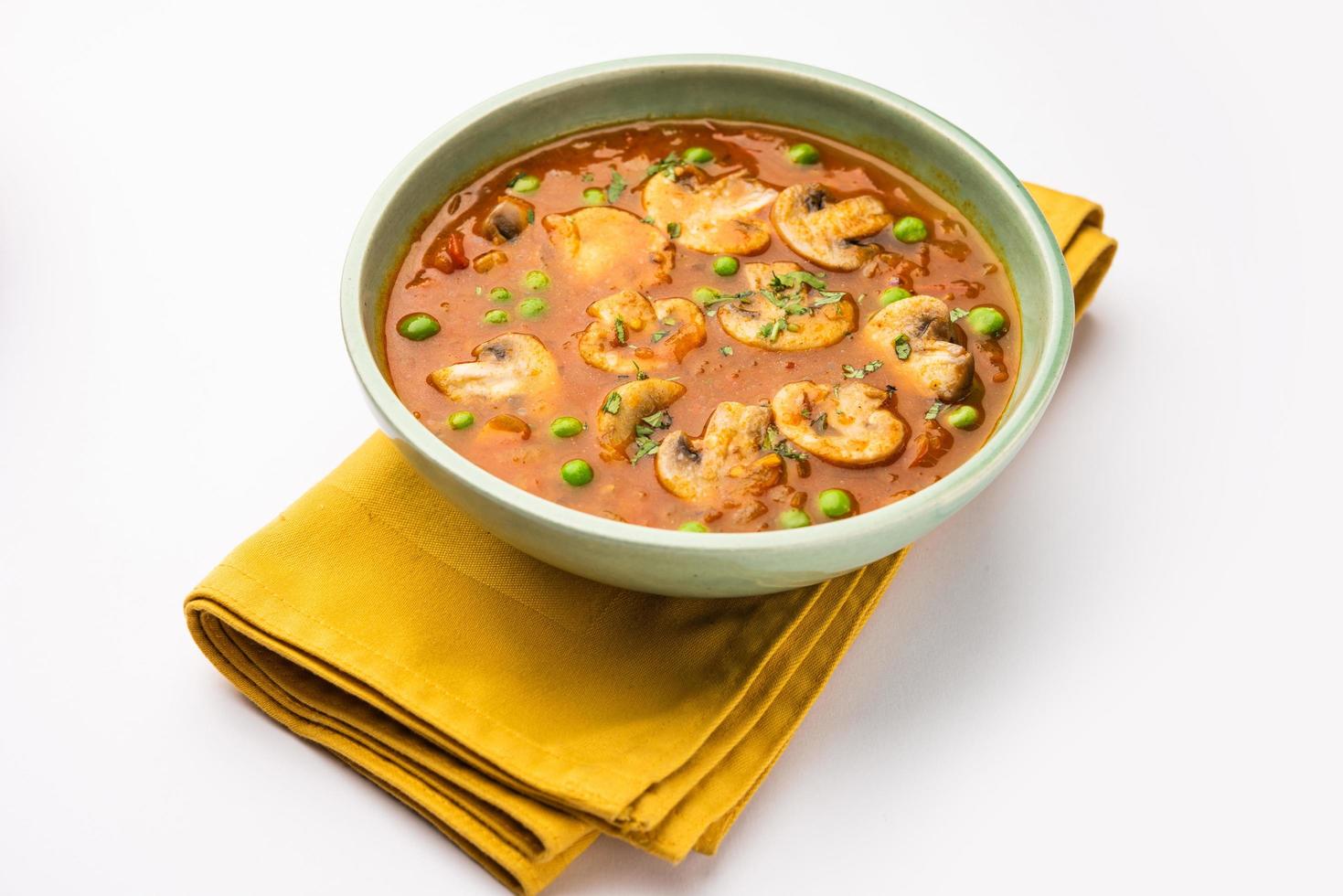 Mushroom and Pea Curry with Roasted Garlic, Indian food served in a bowl photo