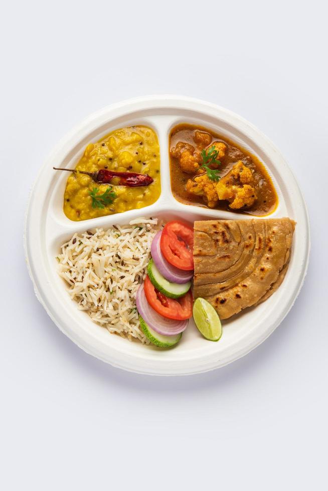 Indian mini meal parcel platter or combo thali with Gobi Masala, roti, dal tarka, jeera rice, salad photo