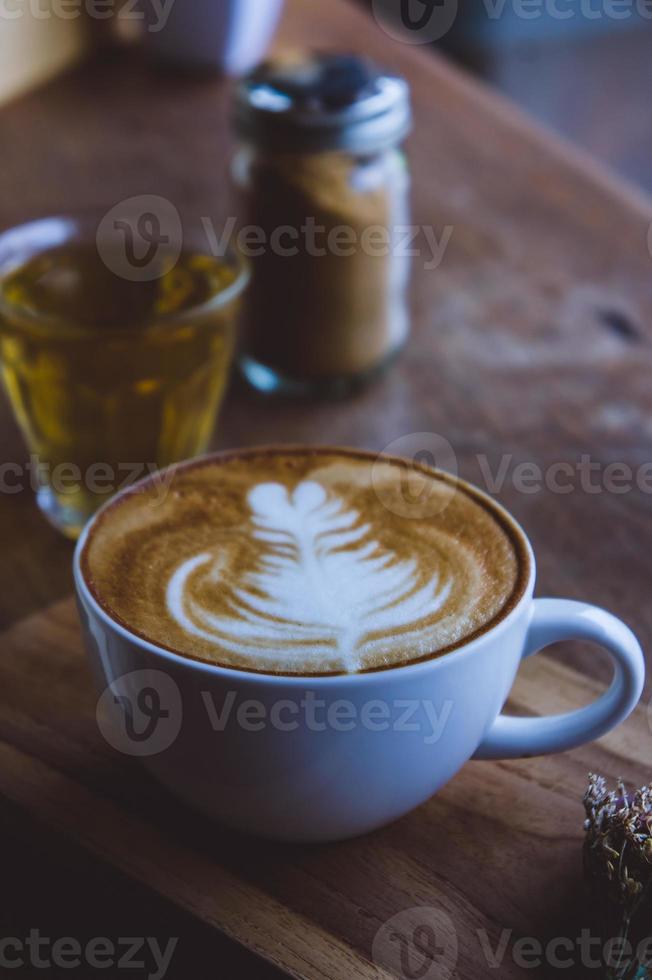 café bebida caliente capuchino arte latte en mesa vintage de madera, tiempo de café en café de fondo de madera foto