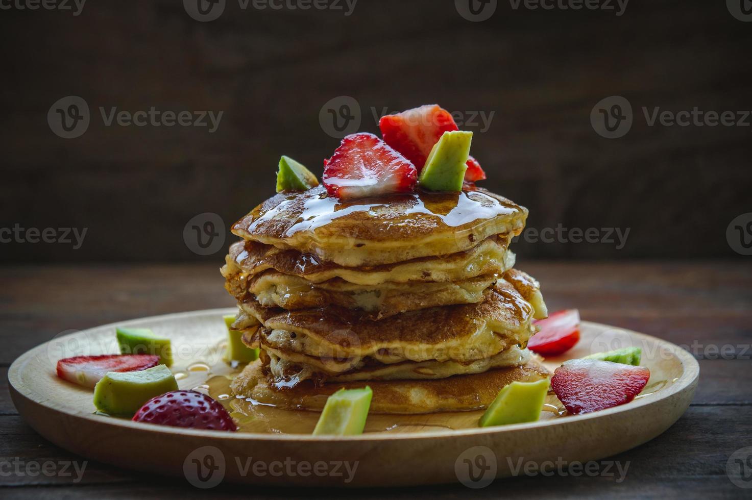 panqueque fresa aguacate fruta y jarabe de miel postre dulce en mesa de madera pan pastel postre casero foto