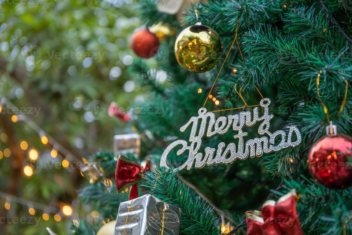 logotipo de feliz navidad en el árbol para el tiempo de navidad foto