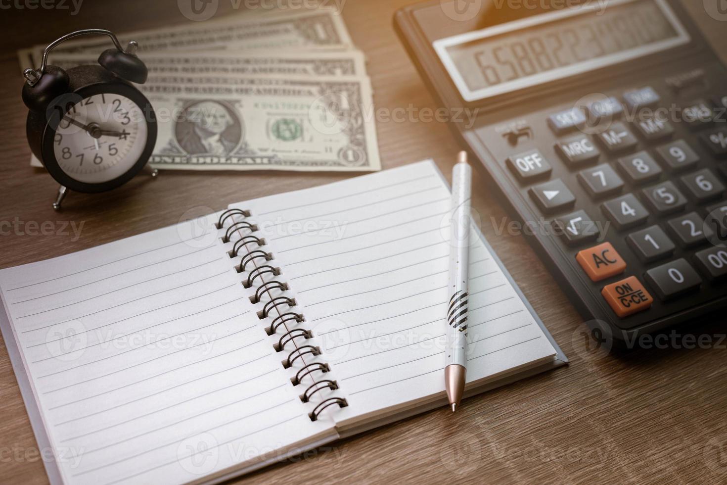 cuadernos, bolígrafos, relojes y calculadoras en el escritorio de madera elementos computacionales finanzas comerciales gastos de tiempo foto