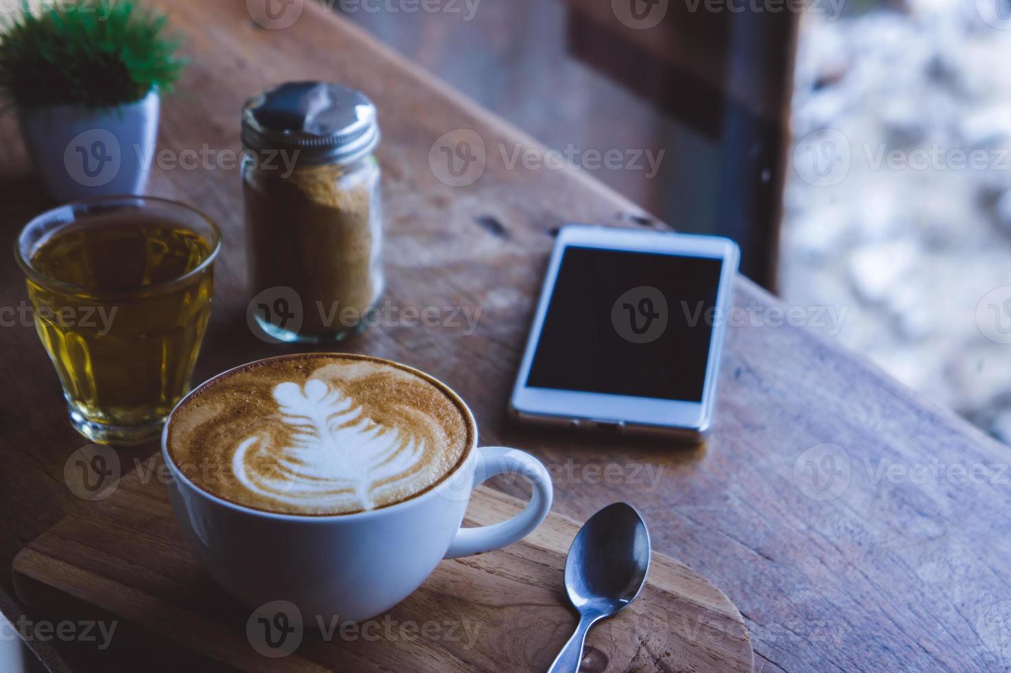 café bebida caliente capuchino arte con leche en una mesa vintage de madera, tiempo de café en un café de fondo de madera foto