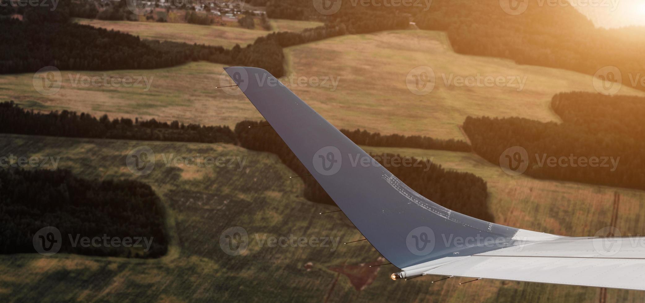 aerial view of landscape with view of aircraft wing photo