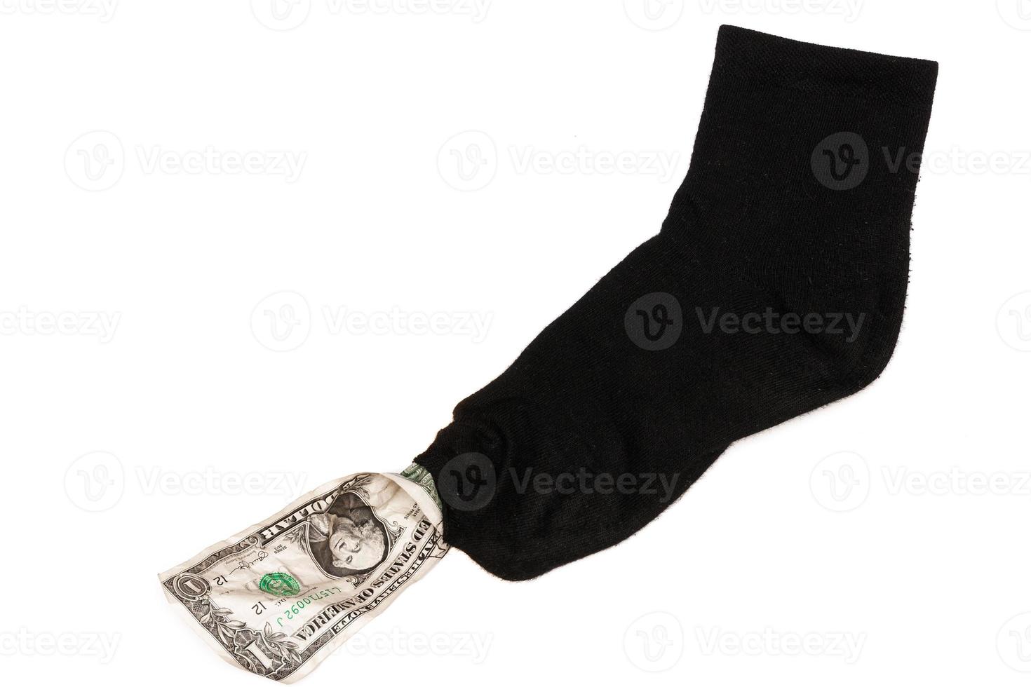 One dollar banknote sticking out from the hole in a sock. photo