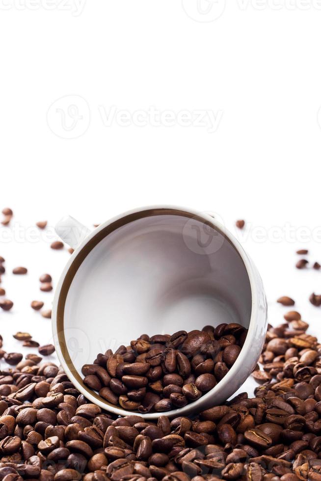 Cup filled with a roasted coffee beans on white background photo