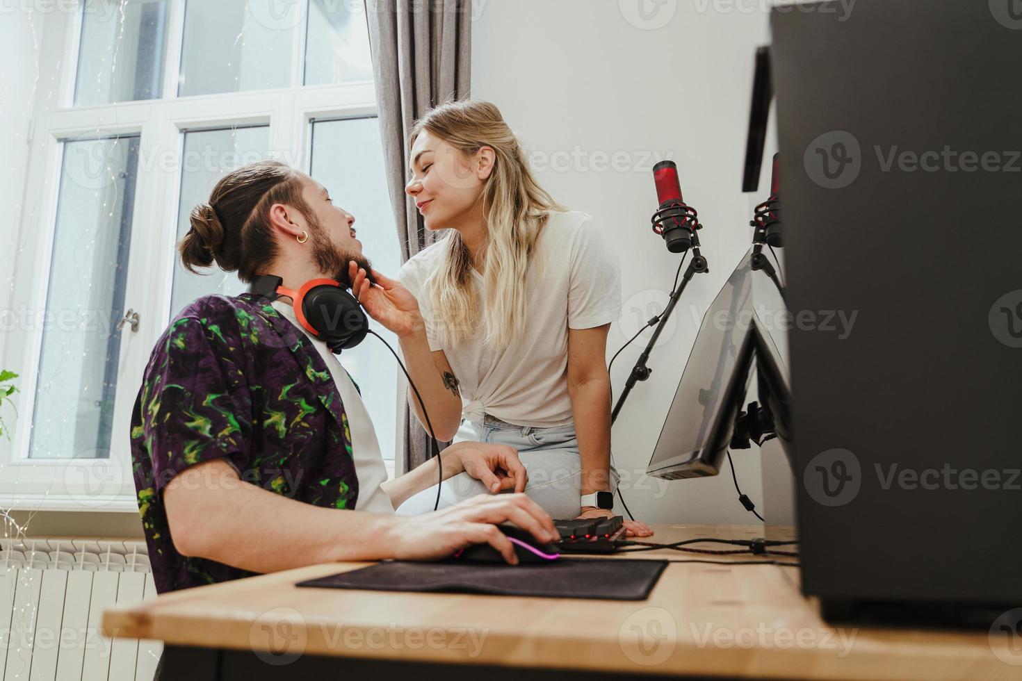 pareja joven relajándose y mostrando amor mientras juega videojuegos en una computadora personal foto