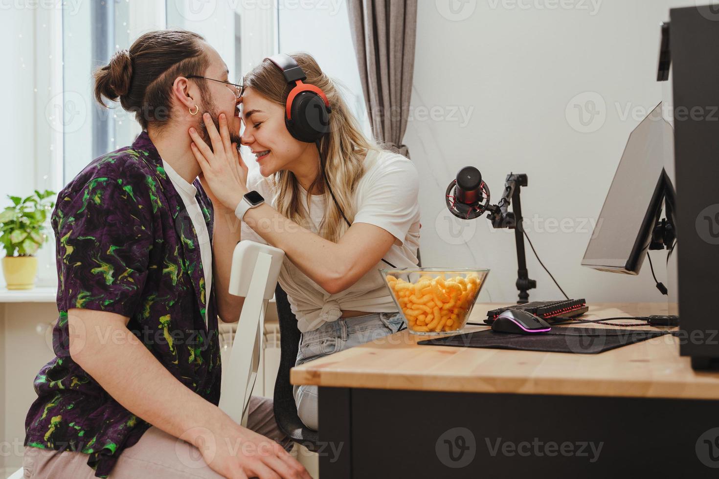 pareja joven relajándose y mostrando amor mientras juega videojuegos en una computadora personal foto