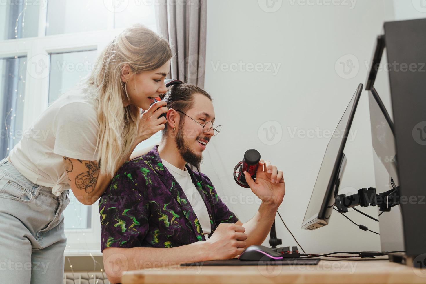 Guy blogger and his beautiful girlfriend at the desk with personal computer photo