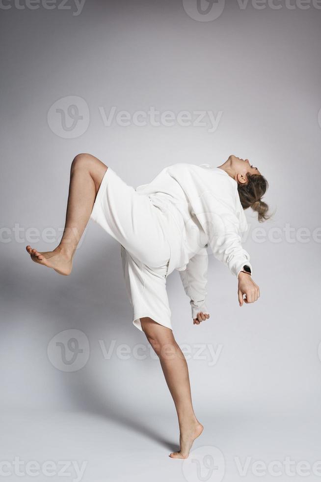 Woman dancer wearing white clothes is performing against on background photo