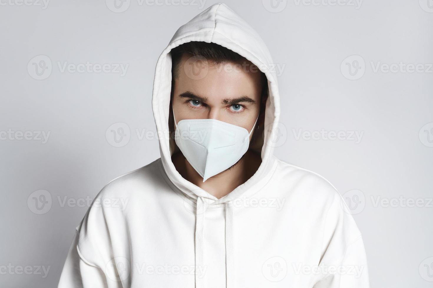 Young man wearing white hoodie and ffp2 respirator mask photo