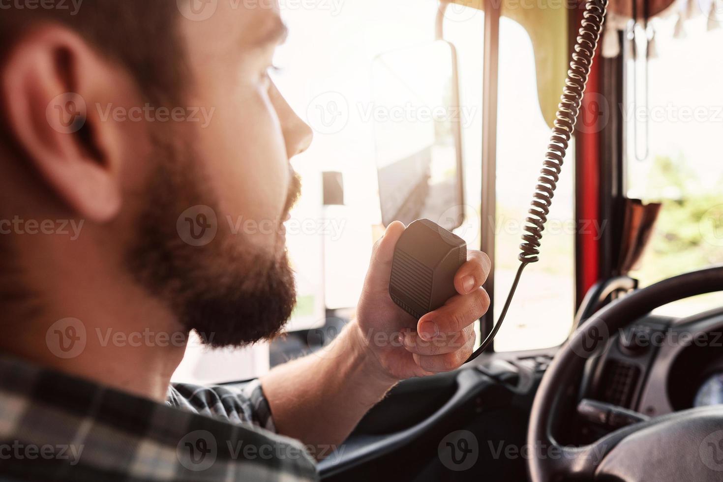 Truck driver talking by CB radio system in his vehicle photo