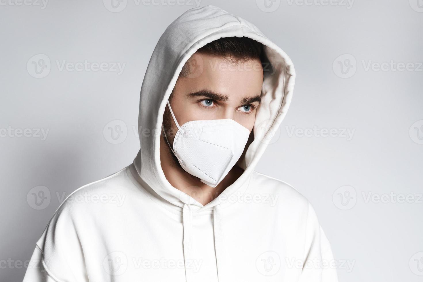 Young man wearing white hoodie and ffp2 respirator mask photo