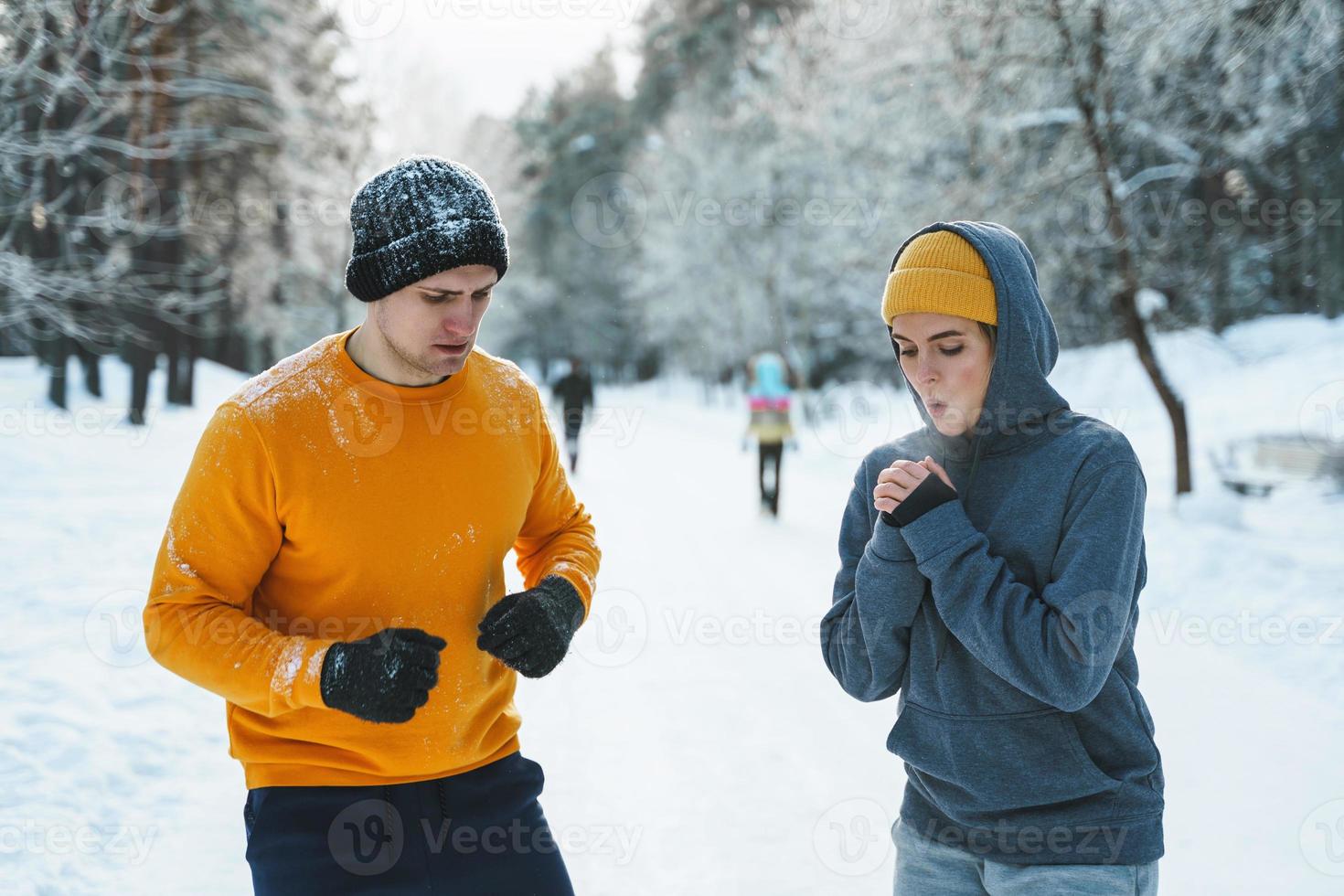 Sportive couple during winter jogging in city park photo