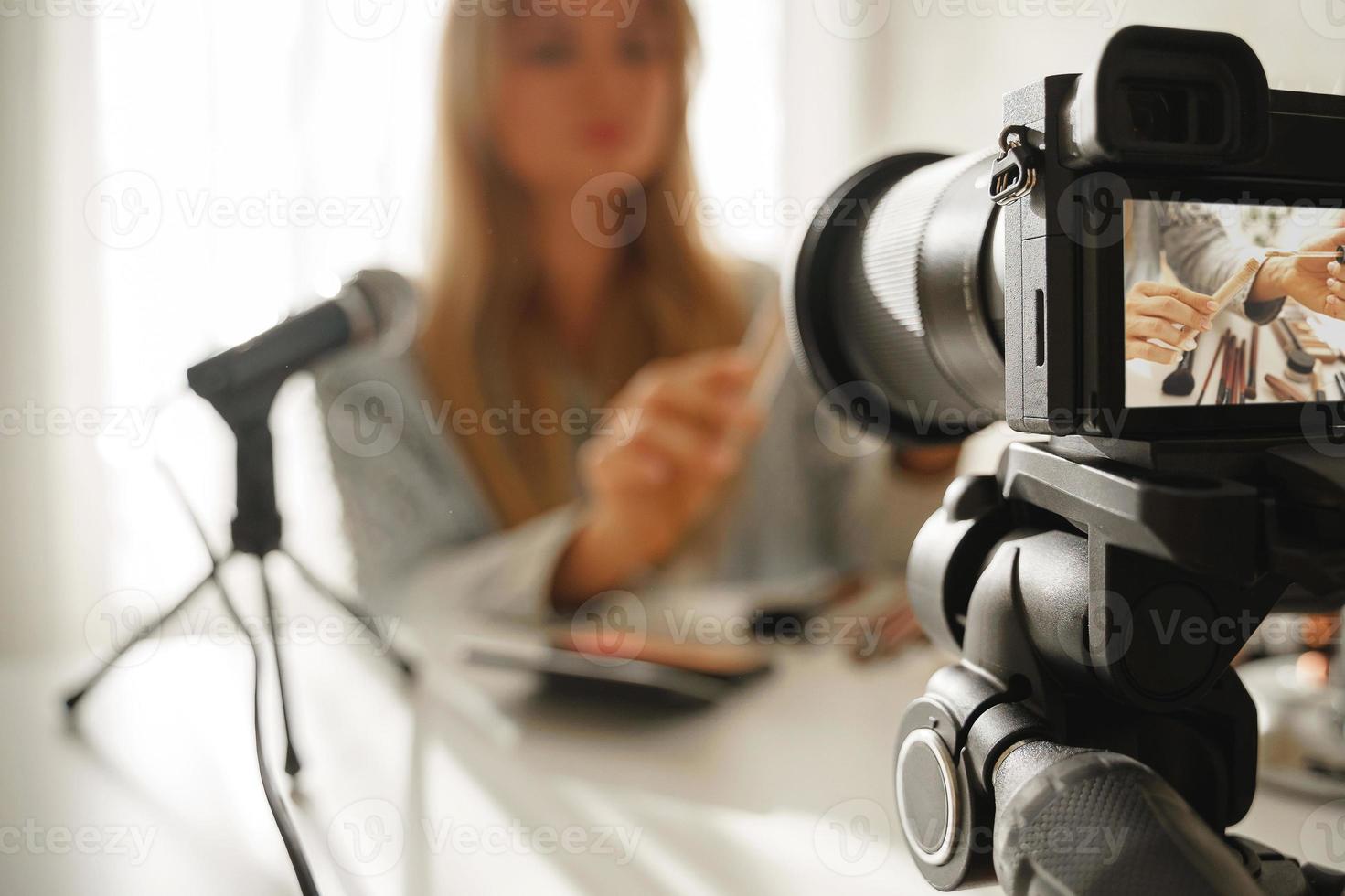 cámara moderna sin espejo grabando video de la rutina de maquillaje de blogger de belleza foto