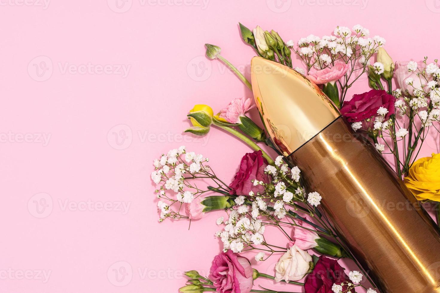 Pacifism and non-violence movement. Bullet and bunch of different flowers against pastel pink background. photo