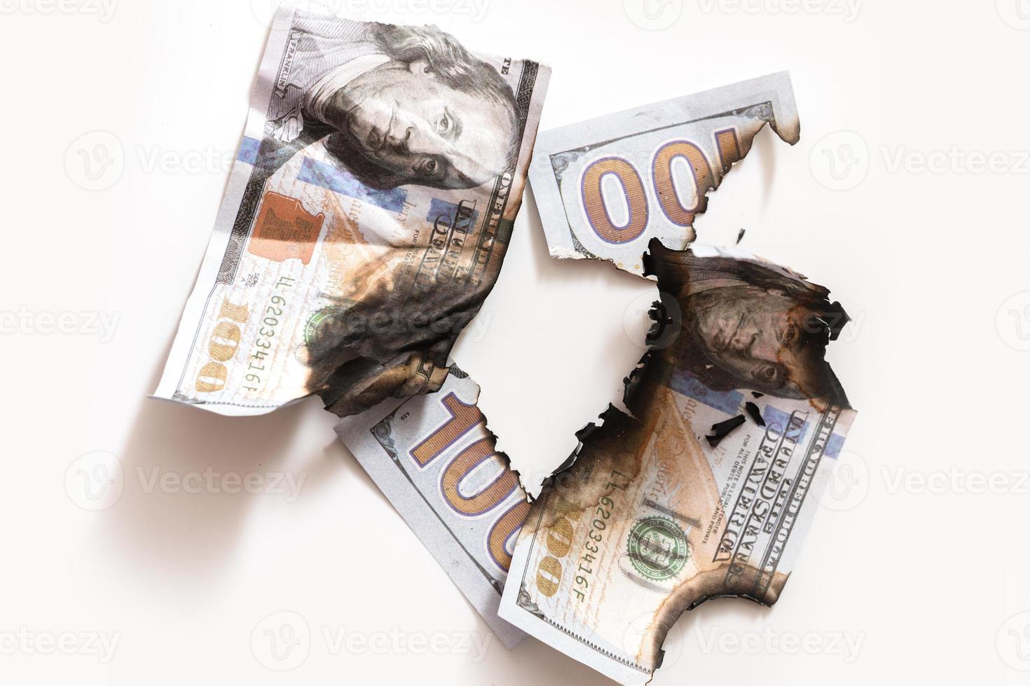 Closeup shot of torn and burnt one hundred dollar bills. photo