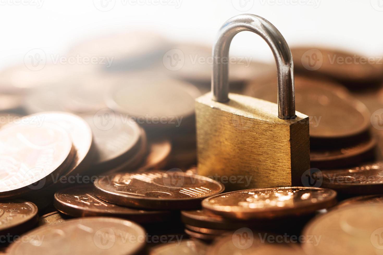 Brass lock on a pile of copper euro coins. photo