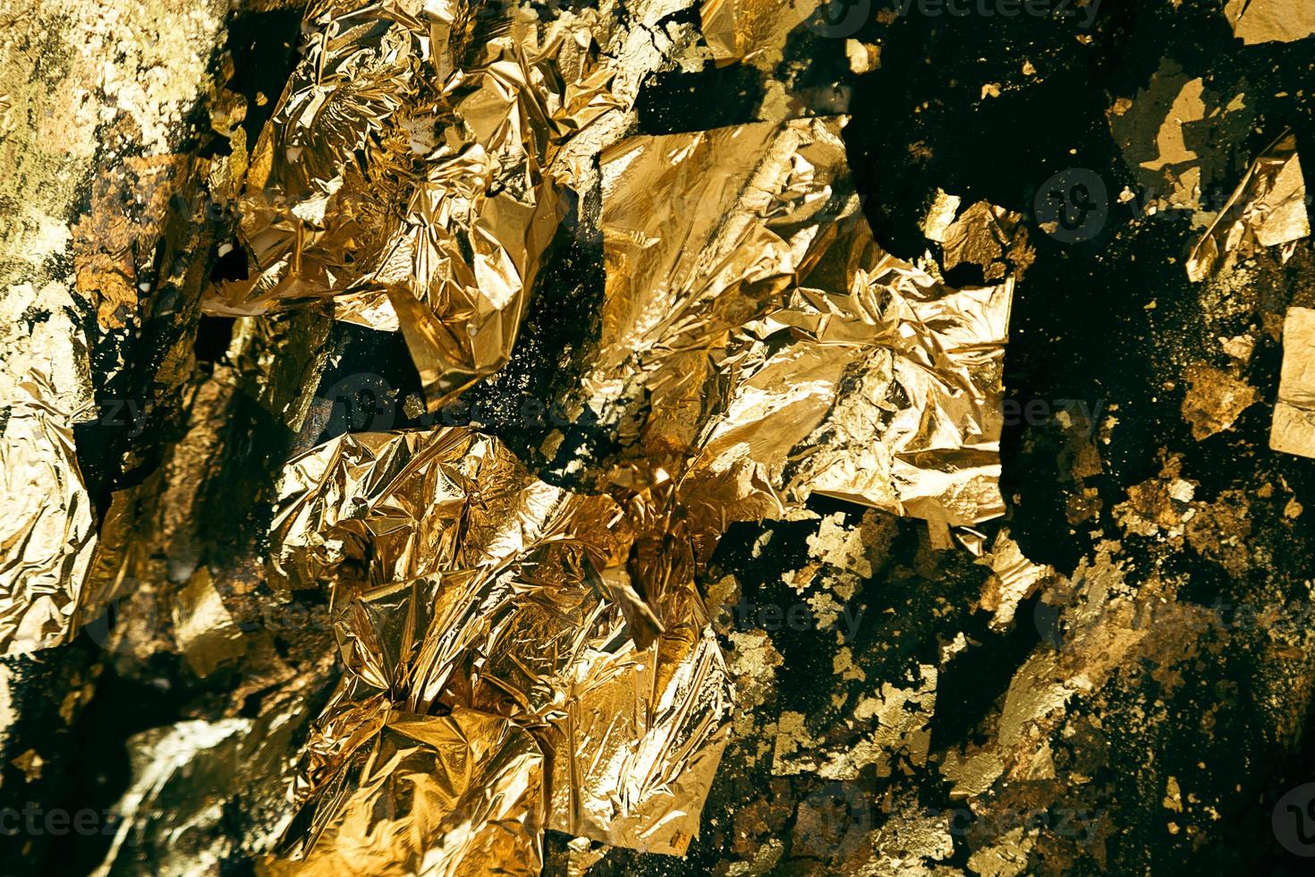 Closeup shot of uneven surface covered with gold foil. photo