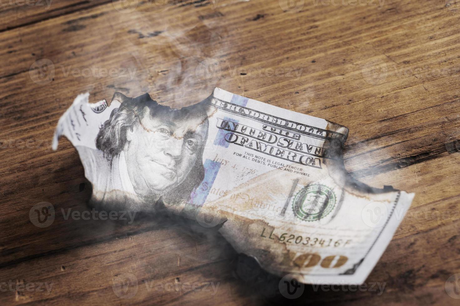 Closeup shot of burnt remainings of a one hundred dollar bill damaged in a fire photo