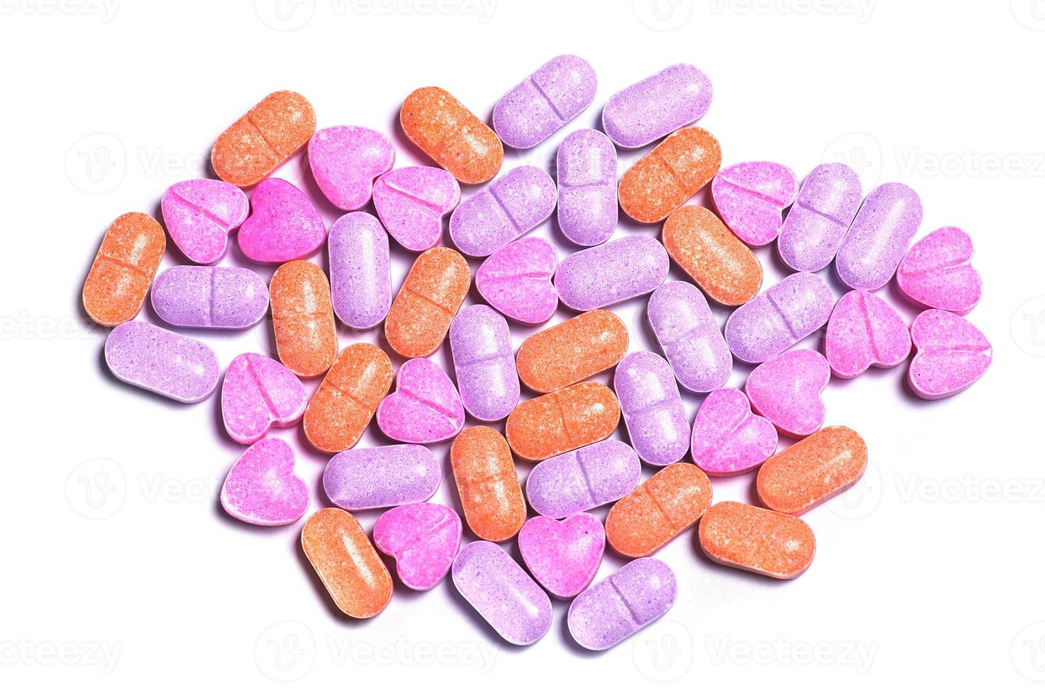 Closeup shot of a pile of colorful pills on white background. photo