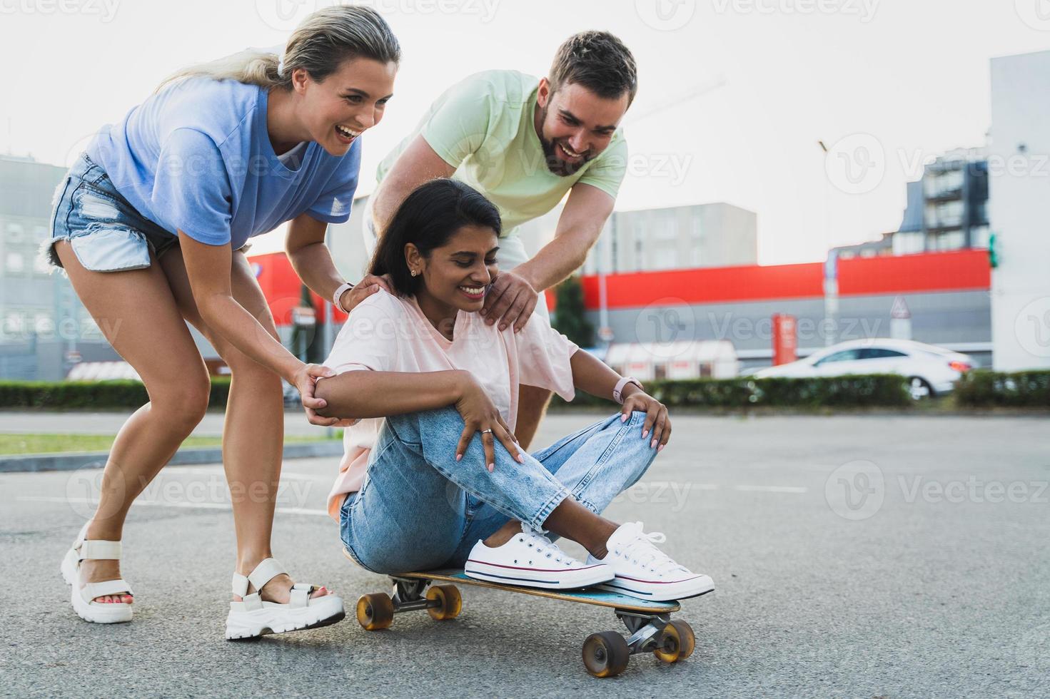 diversos amigos despreocupados divirtiéndose y montando longboard en el estacionamiento foto