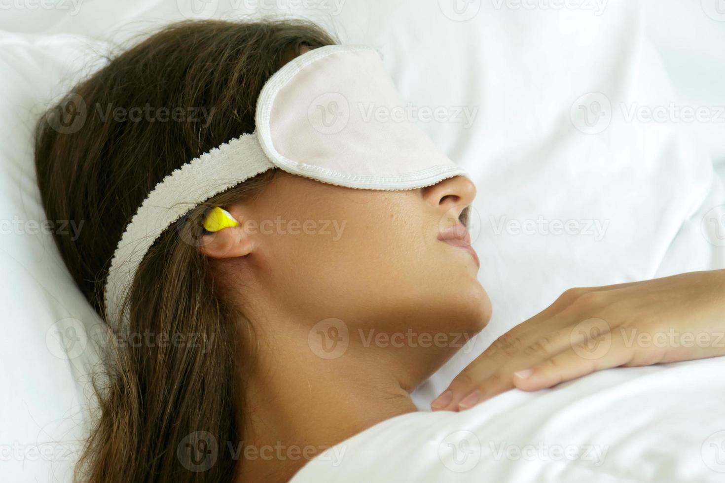 la mujer lleva máscara para los ojos y tapones para los oídos foto