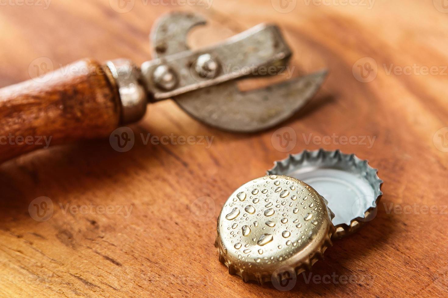 Old opener tool and beer caps photo