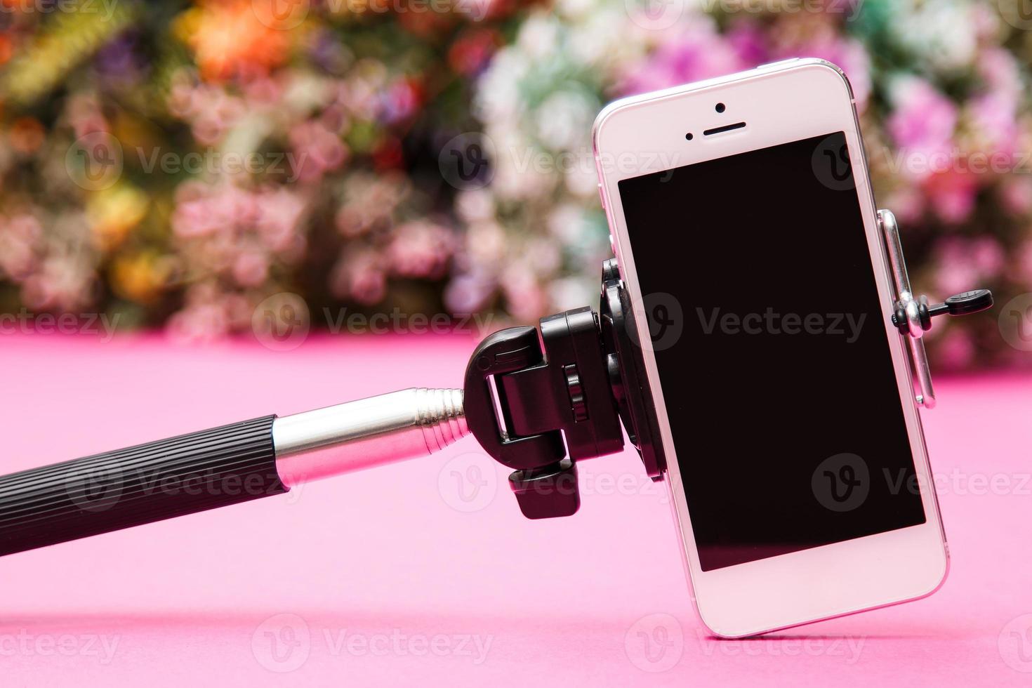 Selfie stick on background with flowers photo