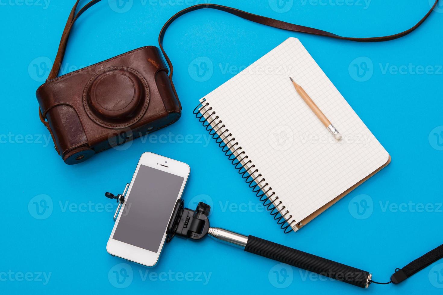 Smart phone on selfie stick and retro camera photo