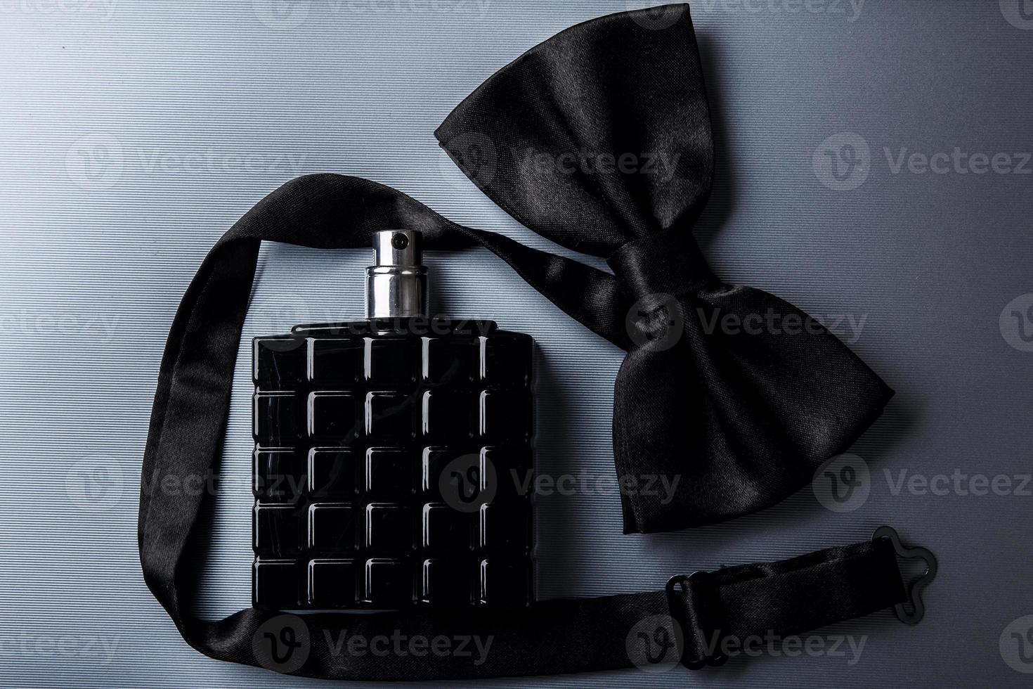 Bottle of male perfume and bow tie photo
