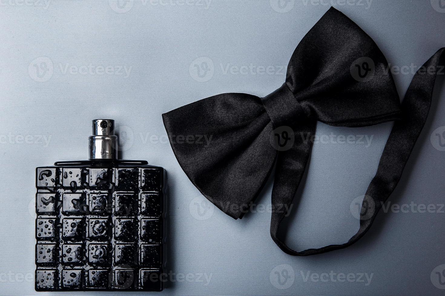 Bottle of male perfume and bow tie photo