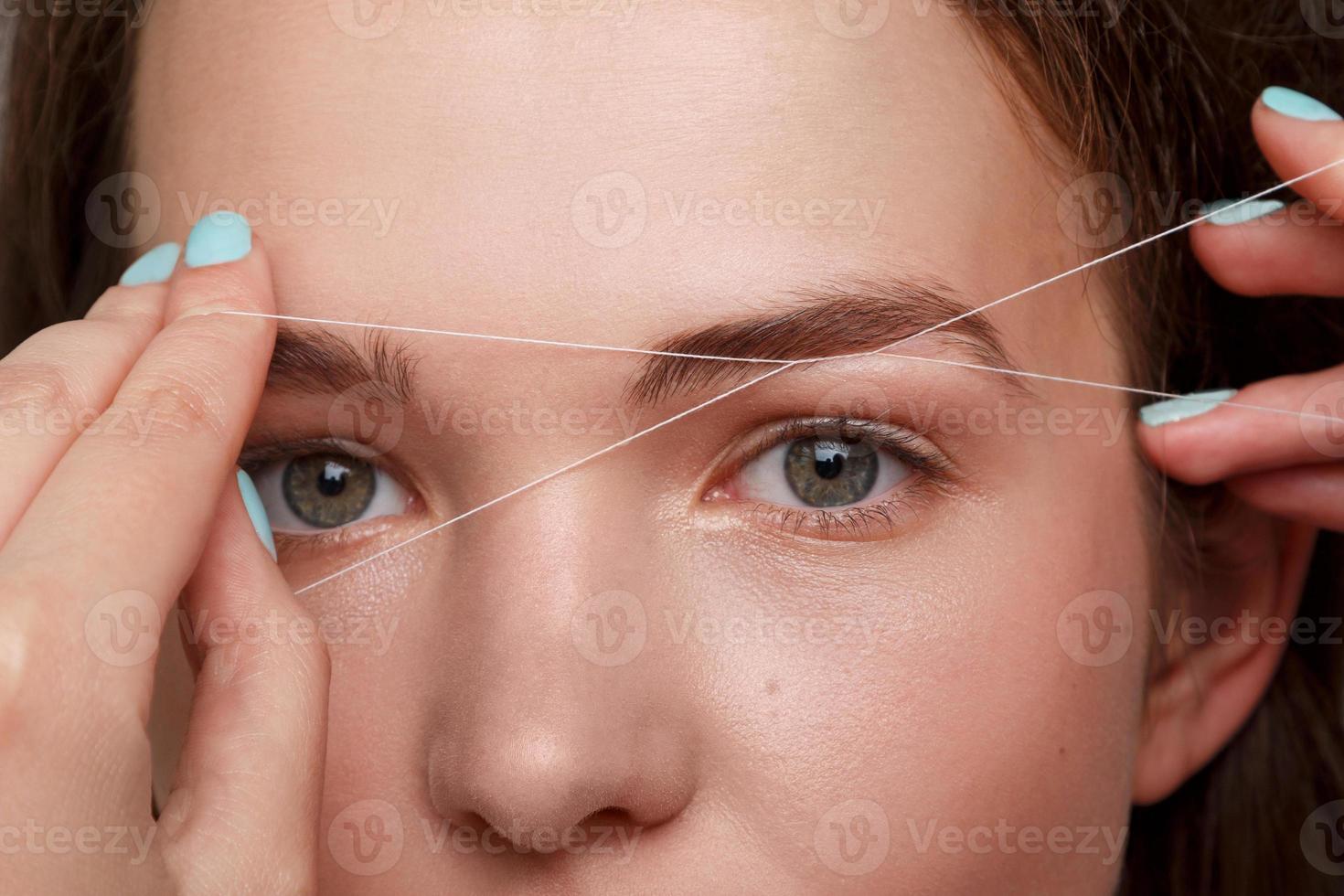 Eyebrow correction with a white thread photo
