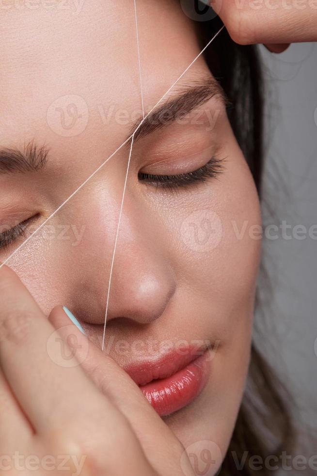 Eyebrow correction with a white thread photo